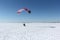 Man with a parachute and a motor, flying in the sky on a winter