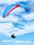 Man, parachute or paragliding in blue sky for adventure, flight freedom or courage with extreme sport. Pilot, nature and