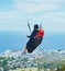 Man, parachute or paragliding in blue sky for ocean view, flight freedom or adventure in extreme sport. Pilot, nature