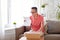 Man with parcel box reading invoice at home