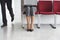 Man Pass By Woman With Laptop On Chair In Corridor