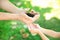 Man passing soil with green plant to his child