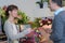 Man paying female florist in flower shop
