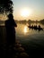 Man paying respect to monks in a boat in the morning