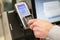 Man paying at the self-service counter entering credit card pin code for security password in credit card swipe machine. shopping.