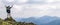 Man on peak of mountain. Emotional scene. Young man with backpack standing with raised hands on top of a mountain and enjoying mo