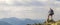 Man on peak of mountain. Emotional scene. Young man with backpack standing with raised hands on top of a mountain and enjoying mo