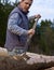 Man peeling bark off tree