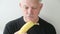Man peels and eats banana