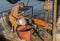 A man peels mussels on a primitive boat or raft on a mussel farm in Saranda,