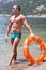 man with perfect abs holds in hands lifebuoy