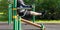 Man performing an exercise, on uneven bars, outdoors, side view