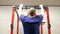 Man performing strength exercise for upper-body on pull up bar at gym