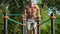 Man performs a power exercise on uneven bars