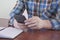 A man with a phone in his hands. Checkered shirt. In the office