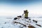 Man with photo camera on tripod taking timelapse photos in the arctic tundra.