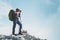 Man photographer with big backpack and camera taking photo of mountains