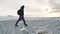 Man photographer with camera walking on snow desert in Iceland. Slow motion shot at sunset or sunrise. Around