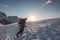 Man photographer climbing on snowy mountain with blue sky at sunset