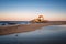 Man photographing beautiful chapel Capela do Senhor da Pedra on the beach at sunset in Miramar, in Portugal