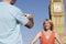 Man Photographing Woman Against Big Ben Tower