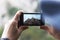 Man photographs on the phone mountain landscape, front view