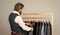 Man picking suit from personal wardrobe, tailored clothes concept