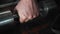 A man picks up a dumbbell from the floor. Close - up of hands