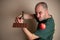 Man picks up a hammer to smash a chocolate bar with one hand and hold an apple with the other