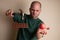 Man picks up a hammer to smash a chocolate bar with one hand and hold an apple with the other,