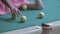 Man in a pink T-shirt lying on a pool table rolls balls into a pool hole