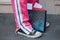 Man with pink tracksuit trousers and small checkered bag before N 21 fashion show, Milan Fashion Week street