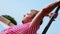 Man in pink tunics posing on camera at beach umbrella. Wind. Summer sunny day. Blue sky