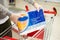 A man places a pack of toilet paper in a shopping cart