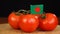 Man placing decorative toothpick with flag of Bangladesh into bunch of tomatoes.