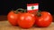Man placing decorative toothpick with flag of Lebanon into bunch of tomatoes.