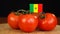 Man placing decorative toothpick with flag of Senegal into bunch of tomatoes.