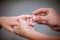 Man placing a diamond engagement ring on finger of his fiance