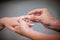 Man placing a diamond engagement ring on finger of his fiance