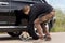 Man placing a hydraulic jack under his car