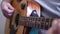 Man playing acoustic wooden six-string guitar