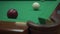 A man playing billiards hit a burgundy ball and scored white in the pocket