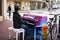 Man Playing a colorfully painted Piano on the sidewalk of a street in Santa Barbara