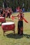 Man playing drums dressed with the traditional attire of Yunnan, in China