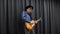 Man playing on electric guitar. Emotional guitar solo playing. Young professional musician guitarist in black stylish hat playing