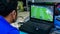 A man playing Fifa 19 on gaming laptop using a console