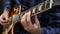 Man playing on guitar. Fingers on guitar fretboard playing chords and solo. Musical instruments concept. Professional guitar lesso