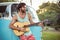 Man playing guitar in front of campervan at campsite