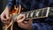 Man playing on guitar. Professional guitarist is holding pick and playing solo on electric guitar. Close up of male fingers perfor