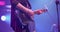 Man is playing guitar on stage. Young man playing on electric guitar. Artist Guitarist hand close-up. Slow motion